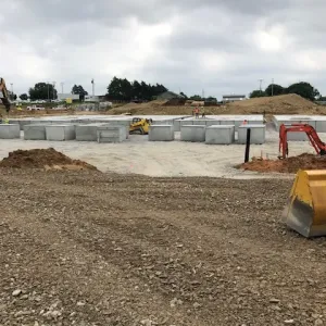 Initial crypt rows set on compacted base rock as site grading continues