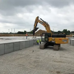 Excavator assisting the crew with crypt lid placement