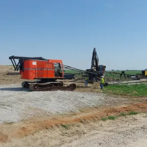 Crew rigging the dragline boom on the access pad ahead of channel excavation
