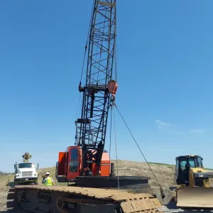 Dragline set on crawler mats with a support crane and dozer on the prepared pad