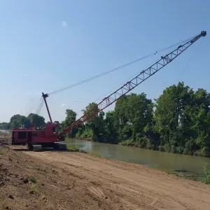 Dragline casting from the top bank to dredge the channel, with the access road graded behind