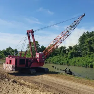 Dragline pulling a loaded bucket up out of the channel