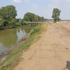 Cleaned channel reach with the graded top bank and spoil placement, looking toward a road crossing