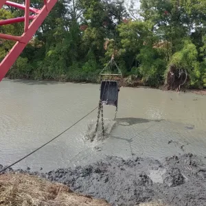 Dragline bucket entering the water on a cleanout pass