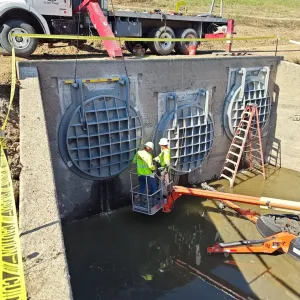 All three 84-inch flap gates hung, with the crew checking level and alignment