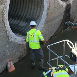 RKE crew member drilling adhesive anchors at a culvert opening ahead of gate installation
