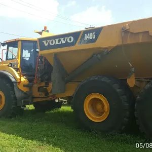Side view of an articulated haul truck with excavated material clinging to the bed