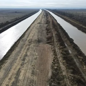 Aerial along Ditch 251 — excavated channel either side of the shaped top bank, running to the horizon