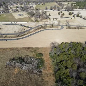 Graded expansion area meeting the existing headstone sections, bounded by the site's treeline