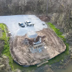 Aerial of the first abutment excavation with formwork set, the gravel staging pad and perimeter silt fence established