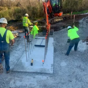 Crew finishing the abutment footing with anchor dowels set for the stem wall