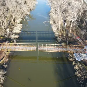 Aerial of both bridge sections landed on their abutments, meeting at the mid-span splice