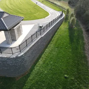 The MSE retaining wall and perimeter fence wrapping the shelter terrace