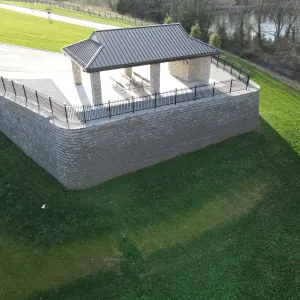 The committal shelter on its walled terrace above the creek