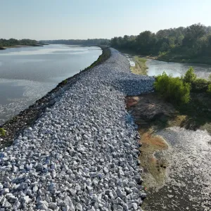Aerial view of the completed riprap blanket running along the riverbank above the landside backwater